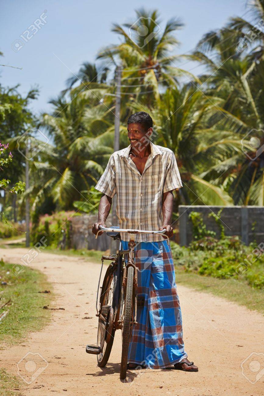22695370-man-with-old-bicycle-in-a-village-in-sri-lanka.jpg