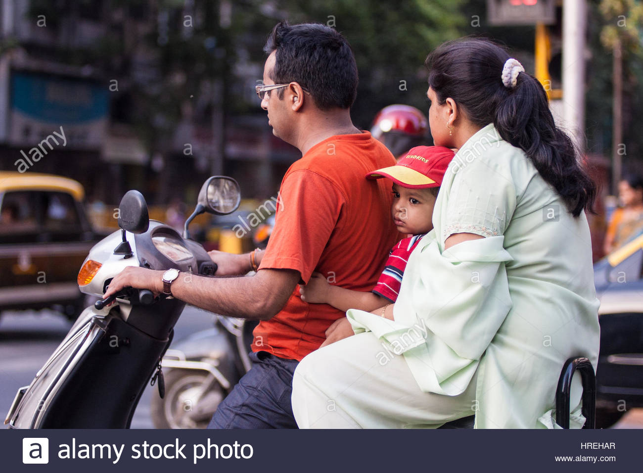 familyonscootermotorbikeintrafficwithouthelmethelmetspollutionveh-HREHAR.jpg