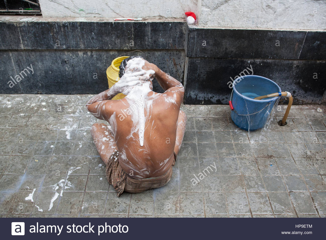 manmalebathingwashinghimselfonstreetpublicwatertapbucketwashkolkatacalcuttawestbengalwest-HP9ETM.jpg