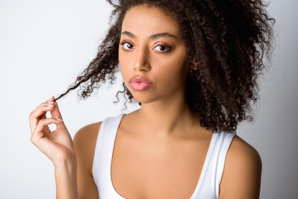 stock-photo-portrait-african-american-girl-holding-her-curly-hair-isolated-grey.jpeg